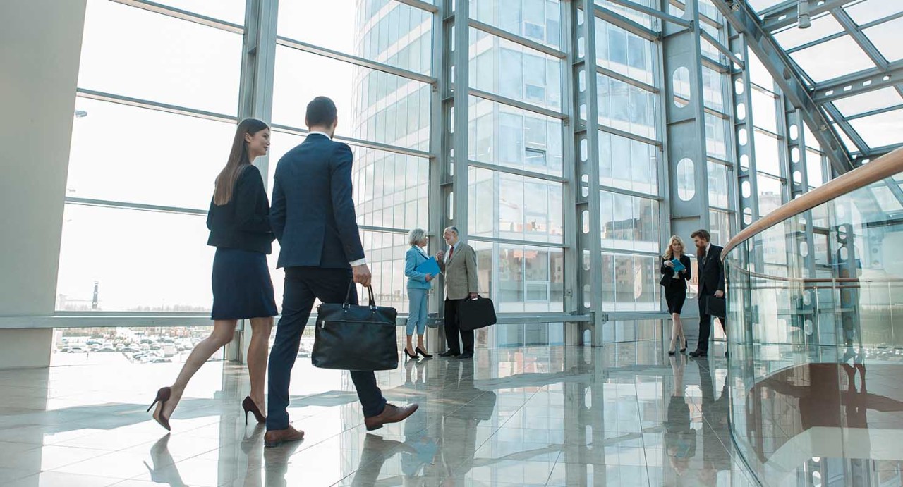 Business people walking in glass building