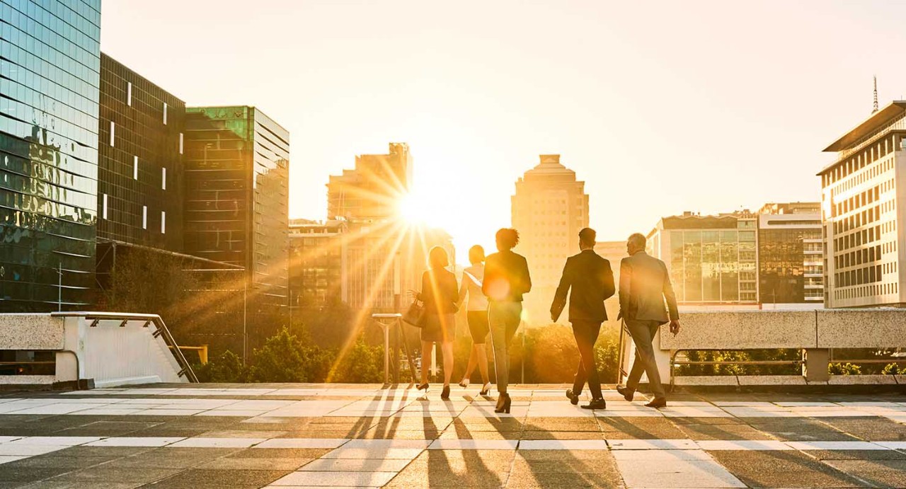 Group of city workers walking with cityscape in background.