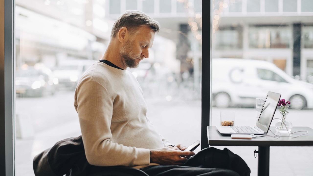 Man with wheelchair with laptop at restaurant