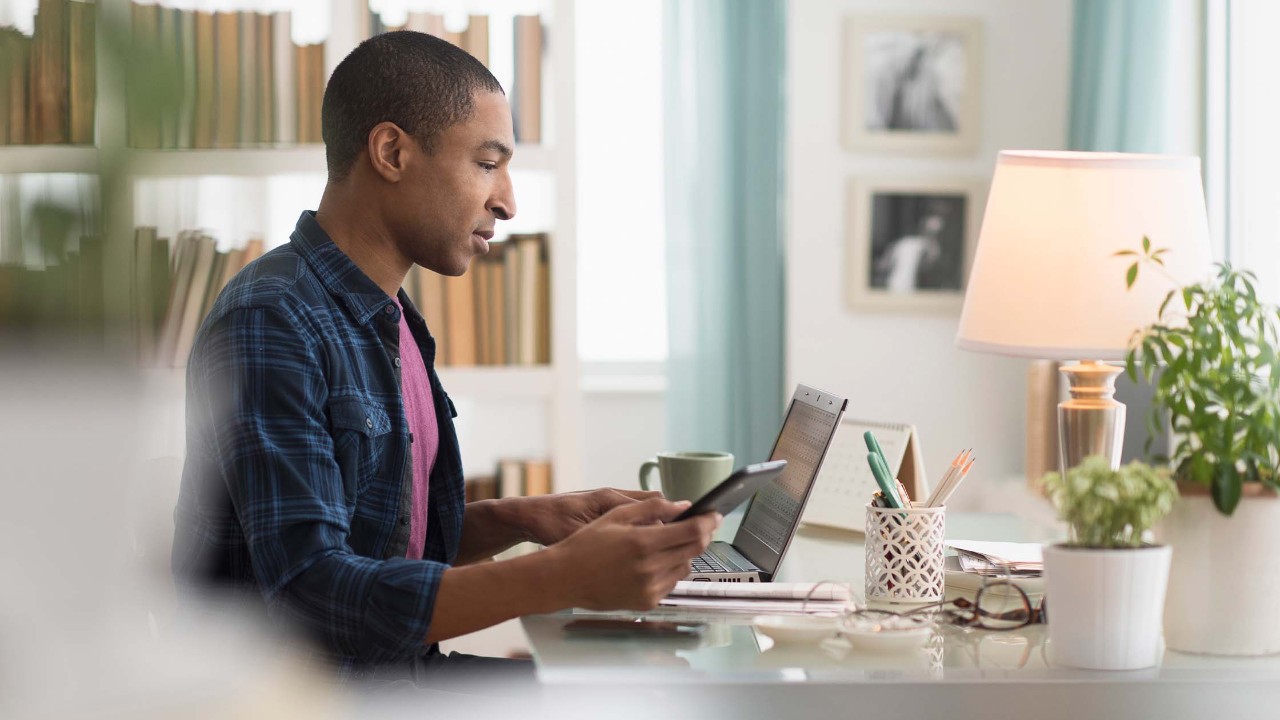 Using cell phone at home office desk